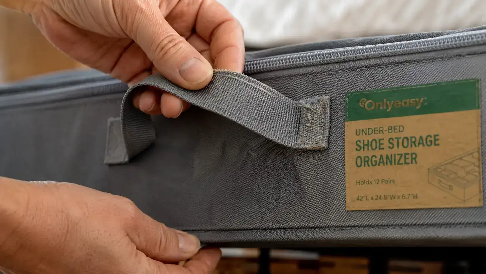 Close-up of under-bed organizer handle stitching showing wear after heavy use