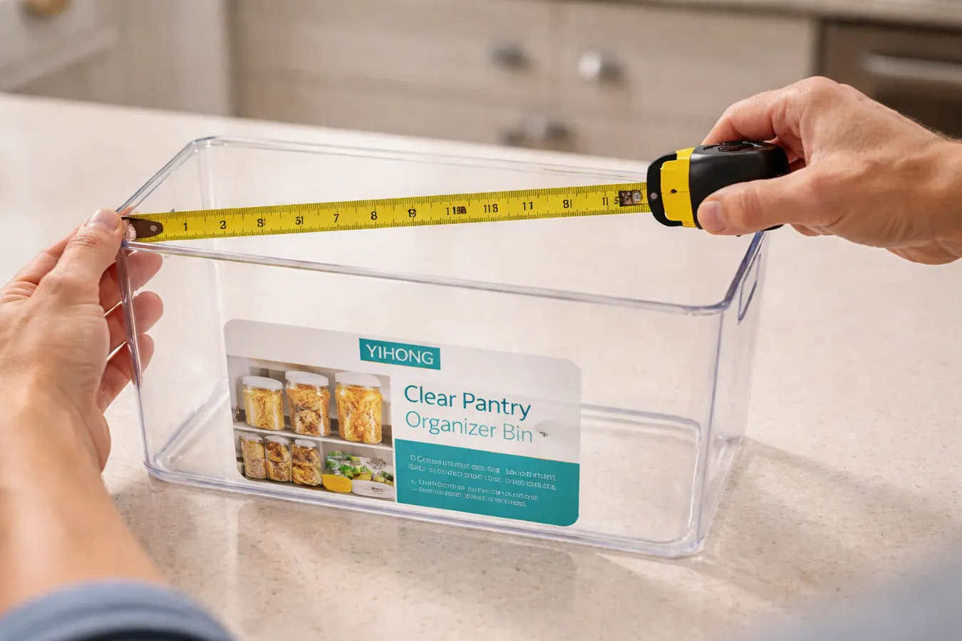 Tape measure laid across the top opening of a clear bin showing interior width measurement